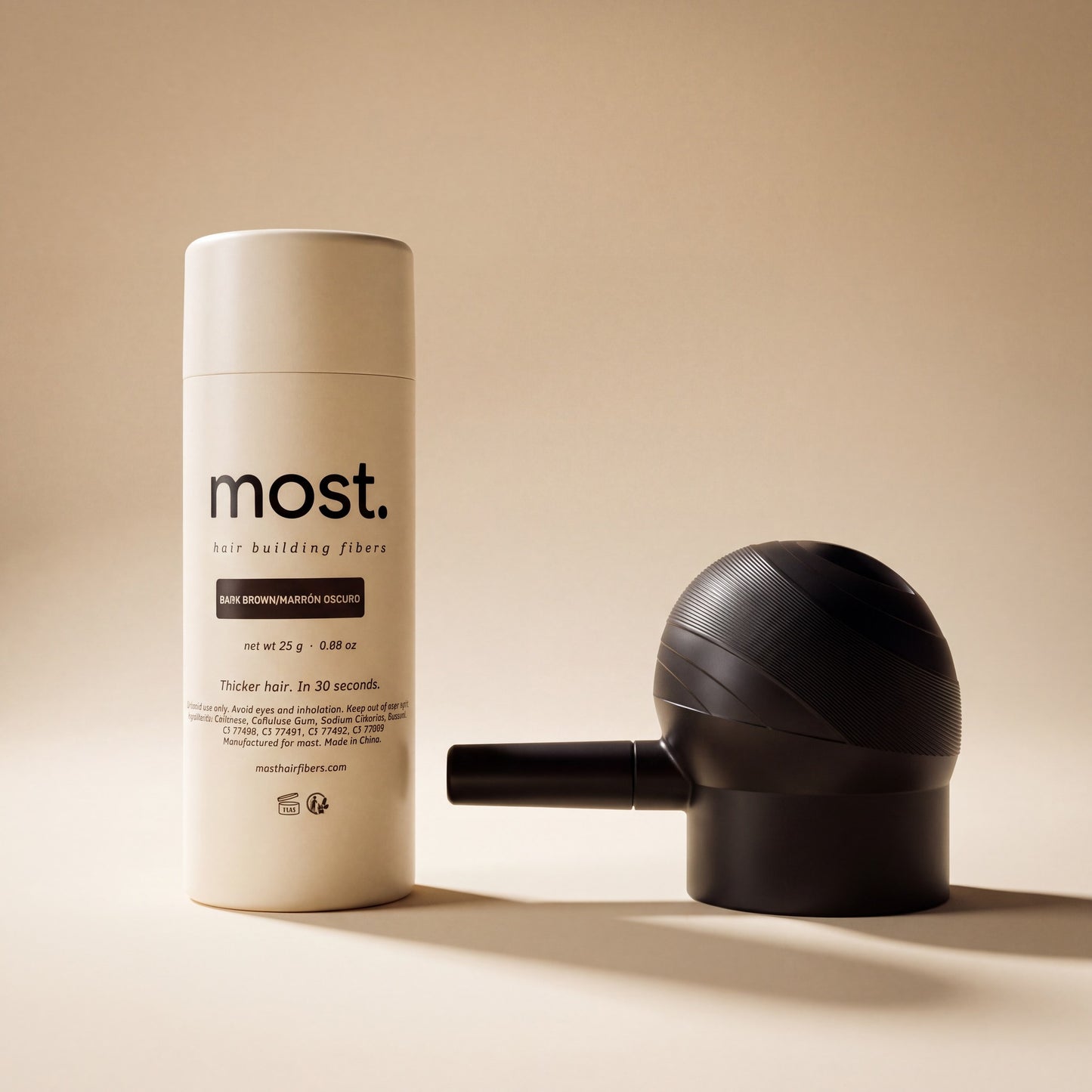 The most. Precision Applicator beside a bottle of most. hair fibers, showing its size