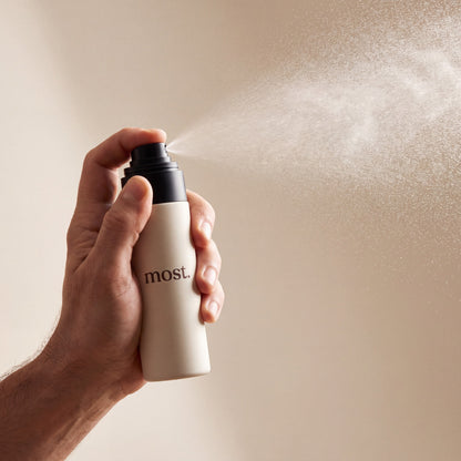 A hand spraying most. AnchorSet, releasing a fine even mist